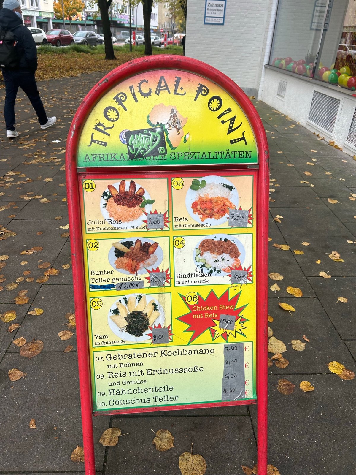 Speisekarte von Tropical Point auf dem Aufsteller vor dem Laden